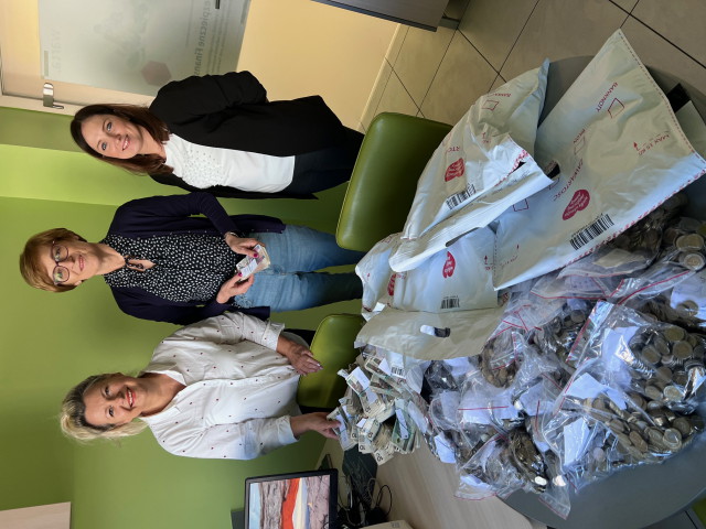 Kolejne zdjęcie z Pracownikami i paczkami z logiem Wielkiej Orkiestry Świątecznej Pomocy